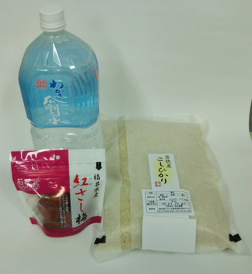 瓜割名水2リットルのペットボトル、コシヒカリ2キロ、梅干しの写真
