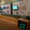ビデオモニターの周りに水月湖年縞堆積物についての説明が掲示されている写真