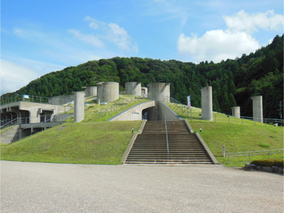青い空と緑の山の手前に、階段と丘のようになった建物が写っている写真(若狭三方縄文博物館)