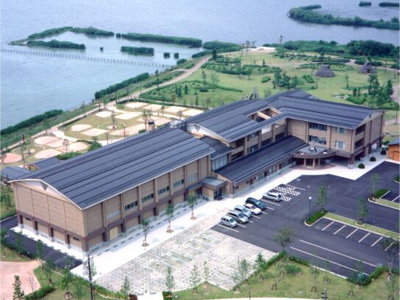 湖の隣に建つL字型の建物と駐車場を上から写した写真(福井県三方青年の家)