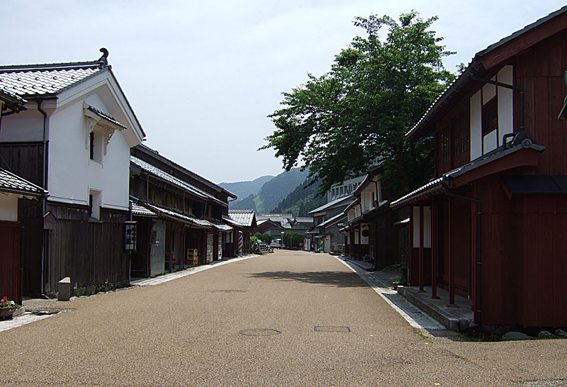 綺麗に舗装された道路の両側に古い建物が奥まで建ち並んでいる写真(鯖街道熊川宿)