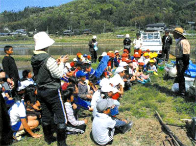 地元小学生たちが観察会のためにかや田に集まっている写真
