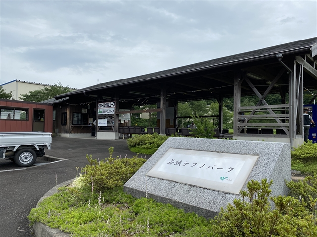 若狭テクノパークと書かれた石看板とその後ろに建つ木造管理棟の写真