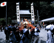 宇波西神社で着物を着た人々が神輿を担いでいる写真