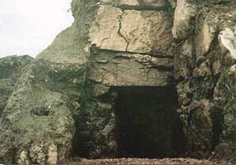 大きい岩が重ねられて作られている横穴式石室の入り口の写真