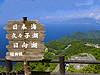 奥に青い湖と緑の山が見える高台で、手前に白字で日本海、久々子湖、日向湖と記載された木製看板が立っている画像