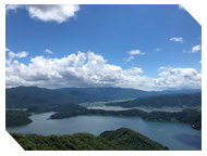 青い空と白い雲、海の間に島や山のようなものが写っている写真